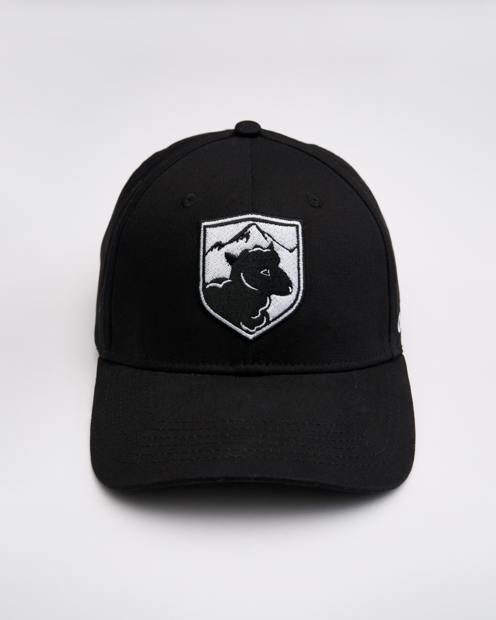 Black cap with a white logo featuring a sheep and mountains